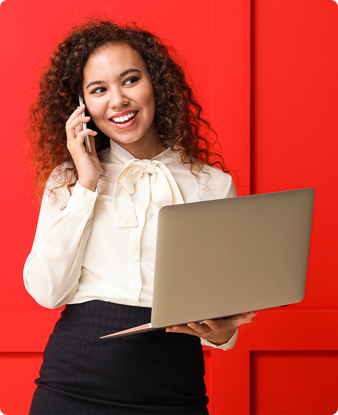 Job seeker looking happy because she is working a good job while on the phone holding her laptop
